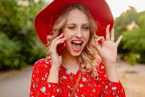 attraktiv eleganta blond leende kvinna i sugrör röd hatt och blus sommar mode foto