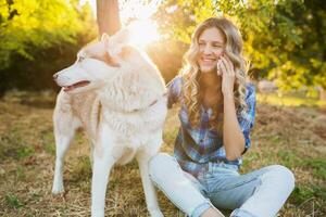 Häftigt ung eleganta Söt leende Lycklig blond kvinna spelar med hund foto