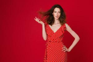 eleganta kvinna i sommar mode trend klänning på röd bakgrund foto