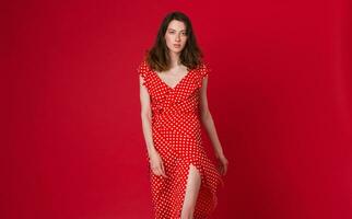 eleganta kvinna i sommar mode trend klänning på röd bakgrund foto