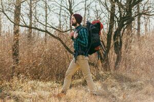 ung hipster man reser med ryggsäck i vår höst skog foto