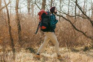 ung hipster man reser med ryggsäck i vår höst skog foto