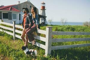 ung eleganta hipster par i kärlek gående med hund i landsbygden foto