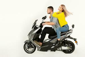 ung attraktiv par ridning ett elektrisk motorcykel skoter Lycklig har roligt tillsammans foto