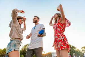 företag av vänner har roligt tillsammans i parkera lyssnande till musik foto