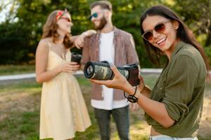 företag av vänner har roligt tillsammans i parkera lyssnande till musik foto