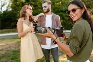 företag av vänner har roligt tillsammans i parkera lyssnande till musik foto