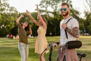 företag av vänner har roligt tillsammans i parkera lyssnande till musik foto