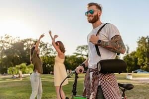 företag av vänner har roligt tillsammans i parkera lyssnande till musik foto