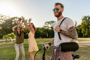 företag av vänner har roligt tillsammans i parkera lyssnande till musik foto