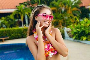 sexig kvinna på sommar semester har roligt på slå samman bär bikini och rosa solglasögon foto
