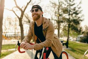 stilig skäggig man reser med cykel i morgon- foto