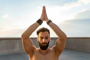 attraktiv hansome man med atletisk stark kropp håller på med morgon- yoga dzen meditation foto
