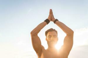 attraktiv hansome man med atletisk stark kropp håller på med morgon- yoga dzen meditation foto