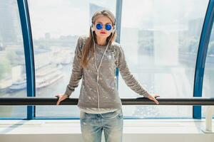 ung hipster kvinna i tillfällig utrusta har roligt lyssnande till musik foto