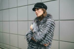 eleganta kvinna i vinter- päls täcka gående i gata foto