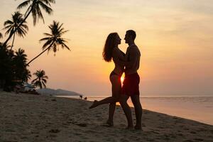 ung sexig romantisk par i kärlek Lycklig på sommar strand tillsammans har roligt bär simma kostymer foto