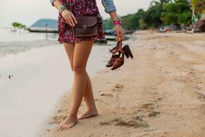 eleganta kvinna i sommar klänning semester gående på strand med skor i hand foto