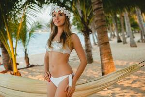 ung sexig kvinna i vit bikini baddräkt på tropisk strand foto
