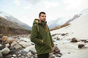 ung hipster man vandring i berg, vinter- semester foto