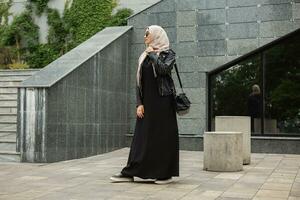 modern eleganta muslim kvinna i hijab i stad gata foto