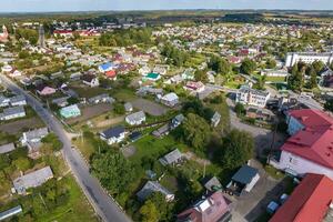 panorama- antenn se av små provinsiell stad eller stor eco by med trä- hus, grus väg, trädgårdar och fruktträdgårdar foto