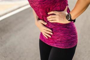 kvinnalöpare som har magkramper efter att ha kört jogging foto