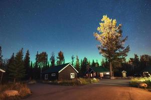 aurora borealis, norrsken med stjärnklart över trästuga i Jasper National Park foto