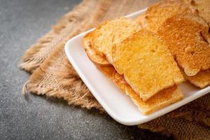 bakat krispigt bröd med smör och socker på tallriken foto