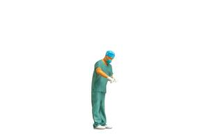 miniatyr- människor ung läkare i scrubs isolerat på vit bakgrund med klippning väg foto