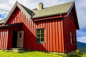 vacker röd trästuga koja på kullen i norge natur.