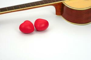 akustisk gitarr nacke och röd hjärta mot vit bakgrund. kärlek, koppla av och musik begrepp. foto