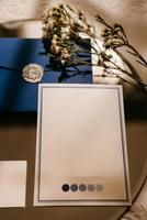 bröllopsinbjudan i ett grått kuvert på ett bord med gröna kvistar foto