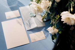 bröllopsinbjudan i ett blått kuvert på ett bord foto