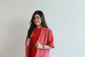 porträtt av ett asiatisk kvinna bär en röd utrusta fira Indonesiens oberoende dag med leende uttryck foto