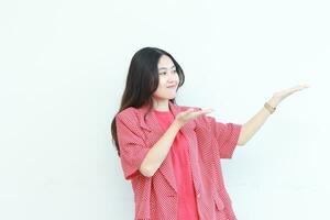 porträtt av skön asiatisk kvinna bär röd utrusta pekande till de sida för kopia Plats foto