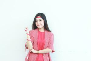 porträtt av skön asiatisk kvinna bär röd utrusta Framställ i anda fira indonesien oberoende dag foto