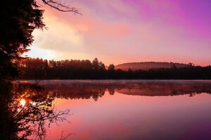 morgon- soluppgång över sjö foto