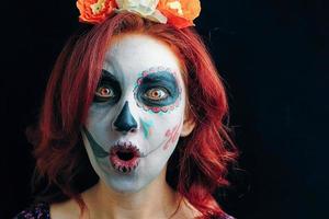 en ung kvinna på dagen för den döda masken skalle ansikts konst. foto