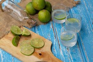 limefruktsaft och citron på ett blått träbord