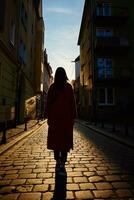 bak- se av kvinna gående på stad gata med solnedgång foto