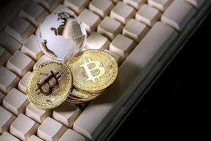 glasglobus och bitcoin-kryptovaluta på tangentbordet. affärsidé foto