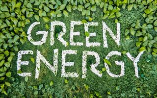 de inskrift grön energi på en bakgrund av grön gräs. jord dag symbol, spara de miljö, grön energi. ai genererad foto