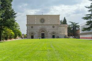 l'aquila, Italien-augusti 11, 2021-vy av de basilika av santa maria di collemaggio i l'aquila under en molnig dag foto