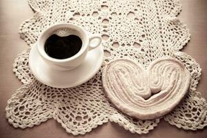 vit kopp av svart kaffe och en ljuv smörig kaka på de tabell foto