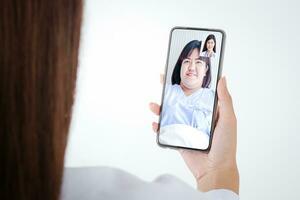uppkopplad läkare begrepp övervaka patient hälsa genom en svart smartphone ansluten till kommunikation via uppkopplad teknologi. de läkare kan undersöka de patient via video ringa upp. vit bakgrund foto