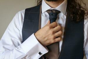 brudgum få redo för hans bröllop och åtdragning hans slips foto