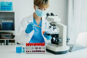 modern medicinsk forskning laboratorium. kvinna forskare arbetssätt med mikro pipetter analyserar biokemisk prover, Avancerad vetenskap kemisk laboratorium foto