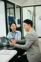 ung attraktiv asiatisk manlig kontor arbetstagare företag kostymer leende på kamera i kontor foto