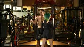 ung man och kvinna lyft hantlar. bodybuilding och utövar begrepp. foto